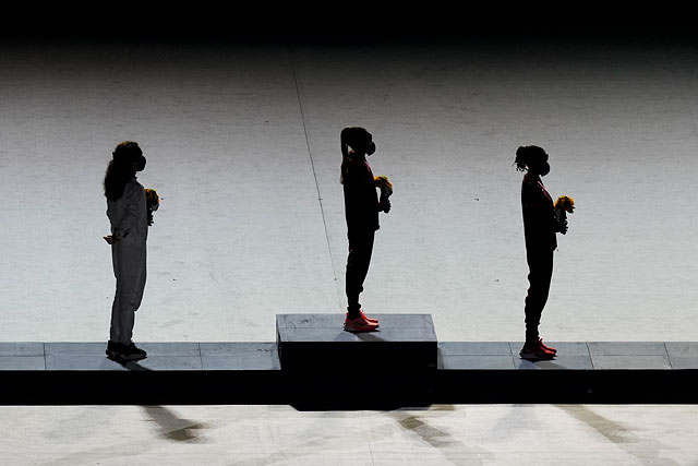 Слева направо: серебряный призер Бригид Косгей (Кения), золотой призер Перес Джепчирчир (Кения) и бронзовый призер Молли Зайдель (США) на пьедестале почета после вручения медалей в женском марафоне во время церемонии закрытия Олимпиады