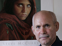 Стив Маккарри рядом со своей знаменитой фотографией афганской девочки