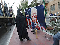 Женщина несет плакат с карикатурой на президента США Джо Байдена на митинге перед бывшим посольством США в честь годовщины его захвата в 1979 году. Тегеран, 4 ноября 2021 года