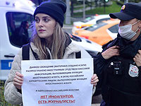 Полицейский задерживает Ирину Долинину из новостного агентства 