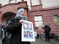 Сирийская женщина Ясмен Алмашан держит фотографии своих пяти погибших братьев перед вынесением приговора бывшему полковнику сирийских спецслужб Анвару аль-Раслану. Кобленце, Германия, 13 января 2022 года
