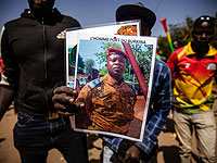 Мужчина держит портрет главы путчистов подполковника Дамиба