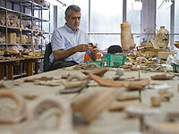 Профессор тель-авивского университета Исраэль Финкельштейн изучает древние украшения найденные недалеко от места библейского Армагеддона на севере страны