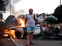 Житель Лода у своей горящей машины во время столкновений с израильскими арабами и полицией. 11 мая 2021 года
