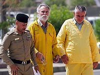 Фолькер Вальдманн (справа) и Джим Фиттон (в центре) в наручниках идут в зал суда. Вальдманна и Фиттона обвиняют в контрабанде древних осколков из Ирака. Ирак, 22 мая 2022 года