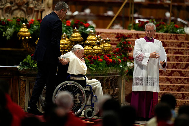 Папский дворецкий Сандро Мариотти (слева) везет Папу Франциска в инвалидном кресле, 5 июня 2022 года
