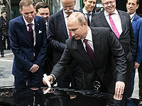 Владимир Путин подписывает капот автомобиля во время церемонии открытия завода по сборке автомобилей Mercedes Benz под Москвой. 3 апреля 2019 года
