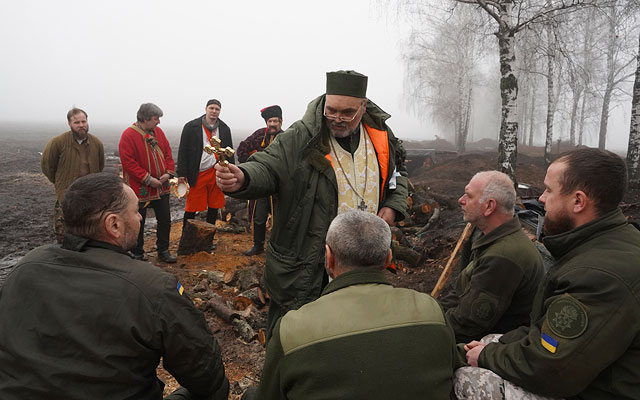 Капеллан благословляет солдат Национальной гвардии Украины отпраздновать Рождество недалеко от границы с Россией недалеко от Харькова, Украина, в субботу, 24 декабря 2022 года