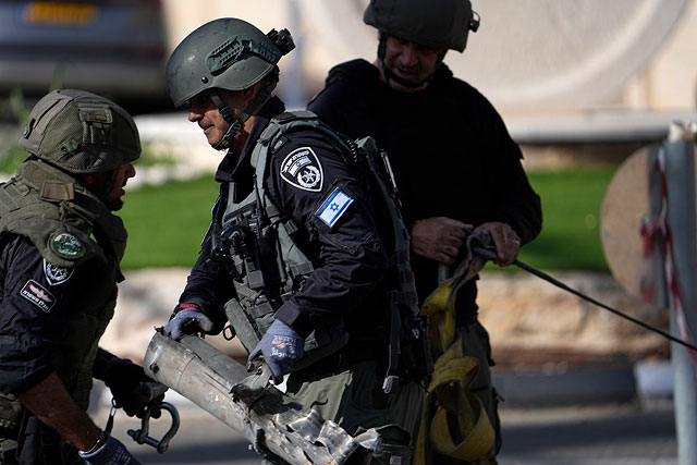 Израильская полиция убирает остатки перехваченной ракеты, выпущенной из Ливана. Шломи, 6 апреля 2023 года