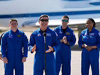 Пилот космического корабля SpaceX Crew Dragon Майкл Бэрратт (второй слева)  вместе с членами экипажа (позади слева направо) - космонавтом Александром Гребенкиным, командиром Мэтью Домиником и специалистом миссии Джанетт Эппс