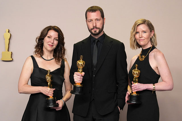 Слева направо: Рэйни Аронсон-Рат, Мстислав Чернов и Мишель Мизнер позируют с наградами за лучший документальный фильм «20 дней в Мариуполе»