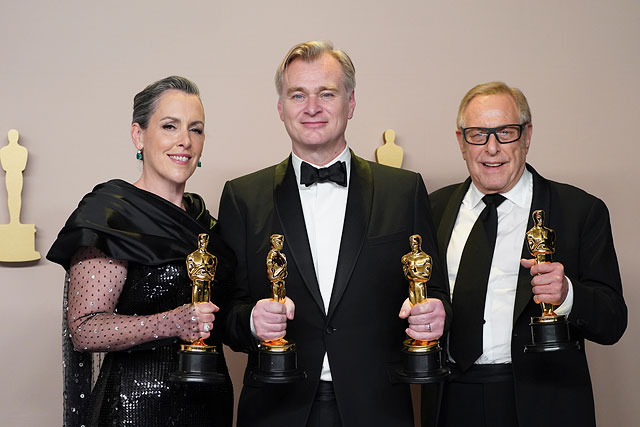 Слева направо: Эмма Томас, Кристофер Нолан и Чарльз Ровен позируют с наградами за фильм «Оппенгеймер»