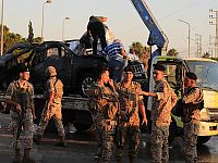 Ливанские военные вывозят то, что осталось от автомобиля, уничтоженного израильскими ВВС в Сайде (архив)