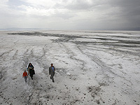 Семья гуляет по застывшей соли на дне озера Орумие в Иране