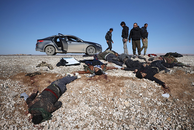 Ополченцы союзные сирийскому правительству осматривают тела отступающих бойцов "Сирийских демократических сил"