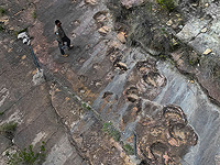 Сотрудник парка рядом с окаменевшими следами динозавров в районе Каррерас Пампа в национальном парке Торо-Торо, к северу от Потоси, Боливия