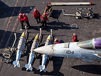 Моряки ВМС США готовят к погрузке боеприпасы на истребитель F/A-18F Super Hornet на борту авианосца USS Abraham Lincoln в рамках операции «Эпическая ярость»