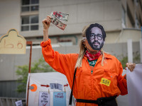 Участница протестов в маске Исраэля Эйнхорна
