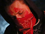 Лицо молодого человека, измазанное красной краской, прикрывал красный платок