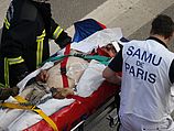 Спасатели эвакуируют раненого с места аварии поезда в Бретиньи-сюр-Орж. 12.07.2013