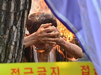 Мужчина, поджегший себя на антияпонской демонстрации в Сеуле. 12 августа 2015 года