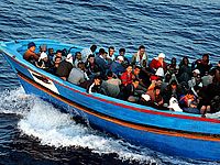 Мигранты на борту лодки, перевозящей их через Средиземное море