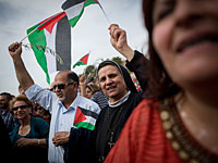 Праздничное шествие католиков в Иерусалиме с пальмовыми ветвями и палестинскими флагами